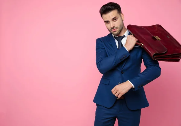 Aantrekkelijke jonge man dragen marineblauw pak en koffer — Stockfoto
