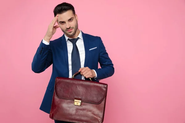 Aantrekkelijke jonge man Holding koffer op roze achtergrond — Stockfoto