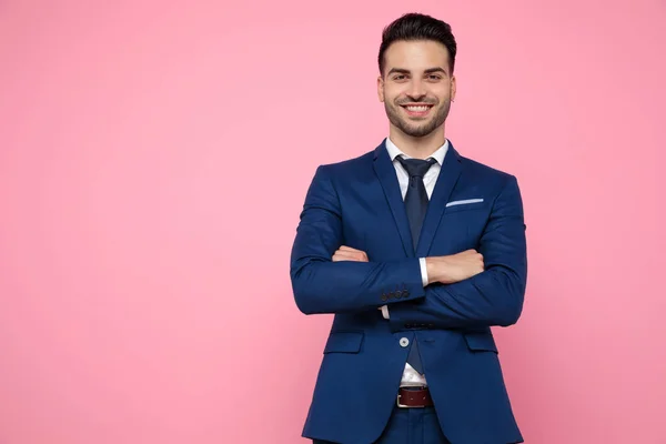 Attractive young man crossing arms on pink background — Stock Photo, Image