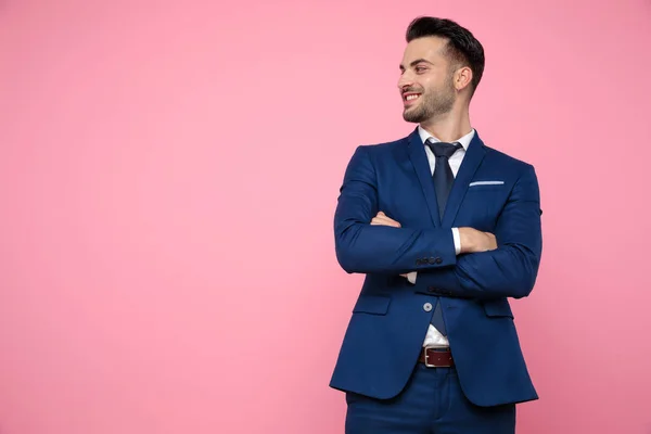 Aantrekkelijke jonge man staand en op zoek naar kant op roze backgr — Stockfoto