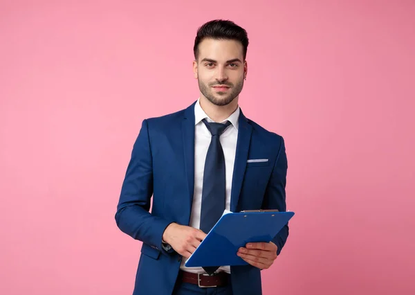 Atraktivní mladý muž držící schránku na růžovém pozadí — Stock fotografie