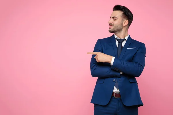 Atrakcyjny młody człowiek wskazując palec na różowym tle — Zdjęcie stockowe