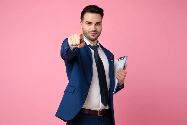 Привлекательный молодой человек держит планшет и указывает пальцем — стоковое фото