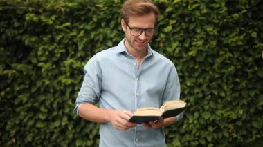 kitap okumak büyük bir zafer demek! Genç mutlu rahat adam okuma tavsiye