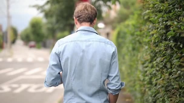 Widok Tyłu Chodzenie Człowiek Tekstylny Jego Telefon Okazuje Się Przywitaj — Wideo stockowe