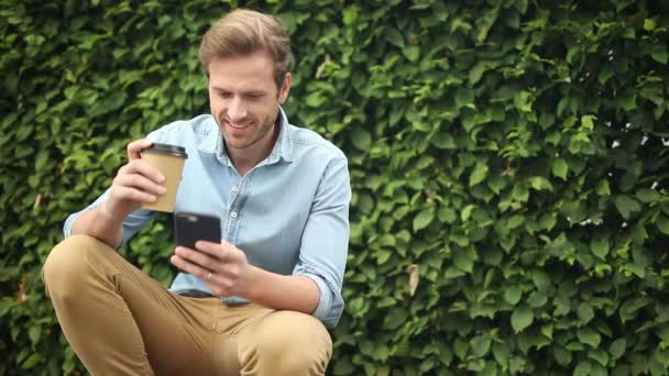 Junger Lässiger Mann Setzt Sich Hin Liest Nachrichten Telefon Und — Stockvideo