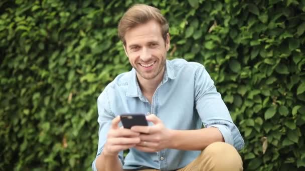 Heureux Jeune Homme Recommande Sur Son Téléphone Faisant Pouce Signe — Video