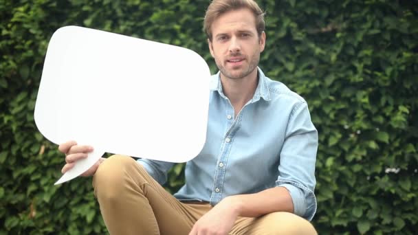Young Casual Man Presenting Blank Speech Bubble Makes Sign — Stock Video