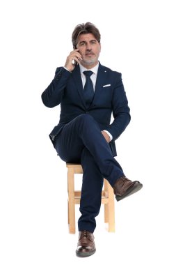 resmi işadamı oturma ve telefonda emin konuşma