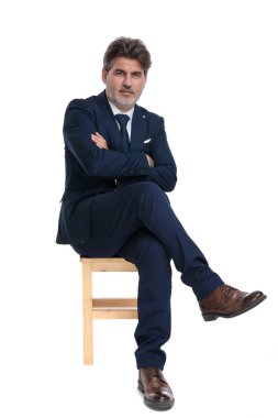 kolları ve bacakları ile oturan işadamı kendinden emin geçti