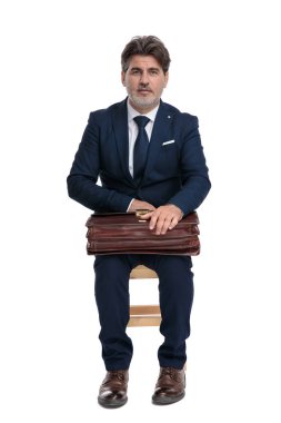 işadamı oturan ve kucağında onun evrak çantası tutarak