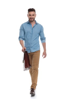 çanta ile kendinden emin yürüyen rahat adam