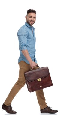 evrak çantası yürüyüş ve kamera bakarak rahat adam