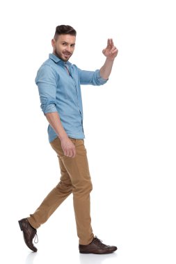 rahat adam yürüyüş ve barış işareti ile kameraya bakıyor