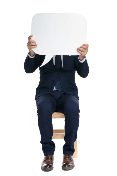 Hombre de negocios formal sentado con la cara cubierta —  Fotos de Stock