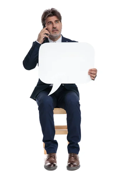 Официальный бизнесмен сидит и разговаривает по мобильному телефону — стоковое фото