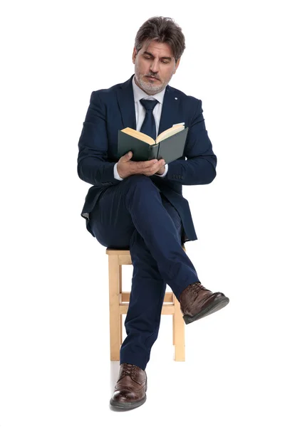 Formele zakenman zitten en lezen van een boek — Stockfoto