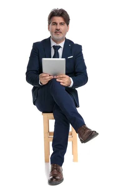 Zakenman zittend met Tablet op handen kijken naar camera gelukkig — Stockfoto