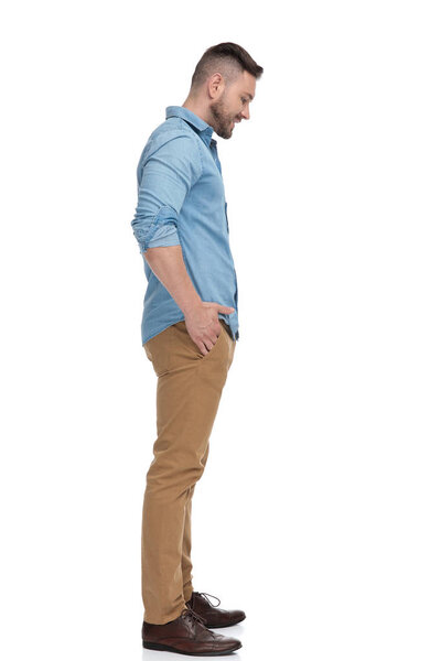 casual man standing in line looking down sad