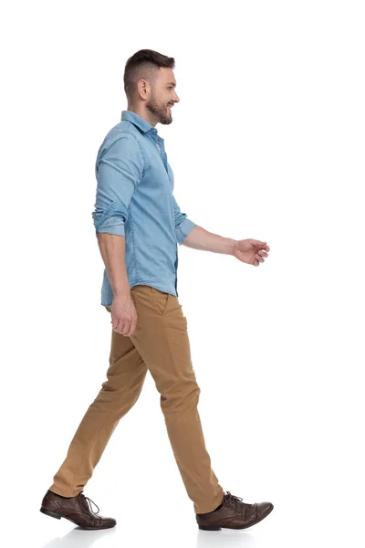 Homem casual com camisa azul andando e olhando para a frente feliz — Fotografia de Stock