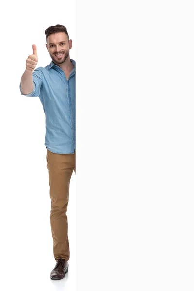 Lässiger Mann, der hinter einer Plakatwand mit einem Ok-Schild steht — Stockfoto