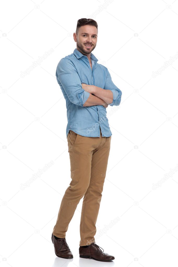 casual man walking with hands crossed happy