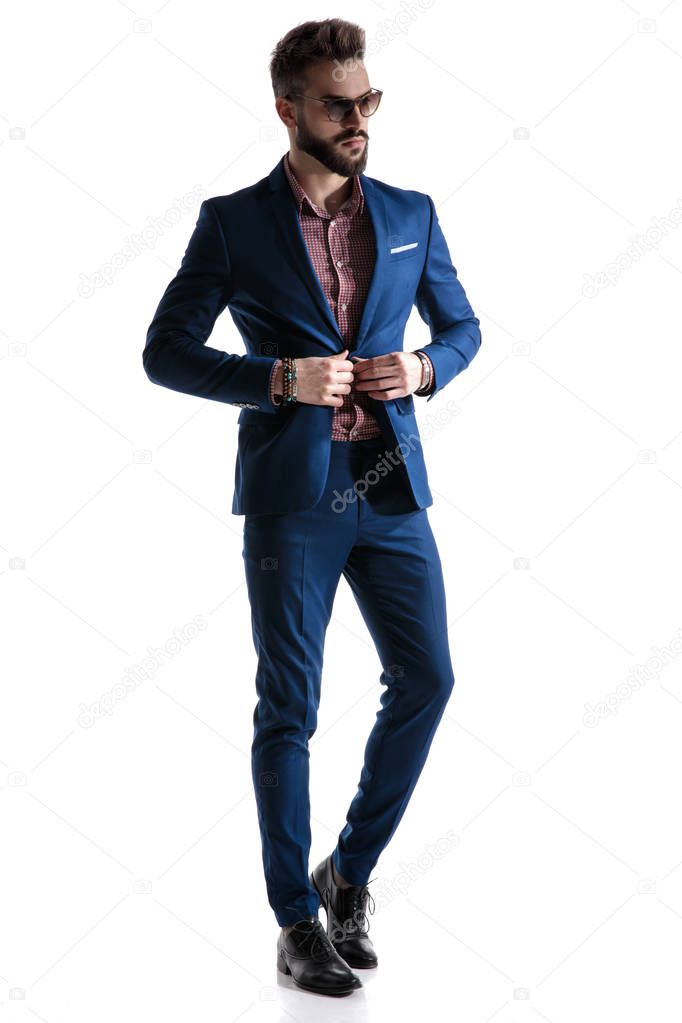 formal businessman in blue suit fixing coat