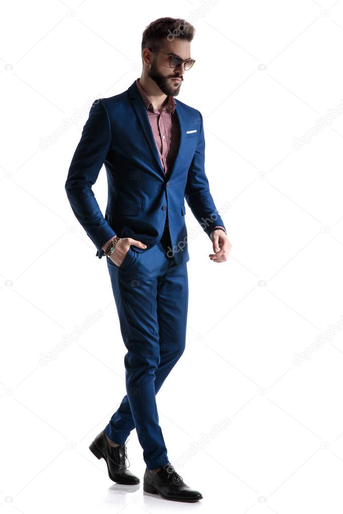 formal businessman walking confident with hand in pocket