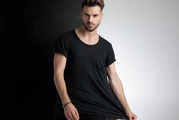 Arrogant young man holding t-shirt in studio — Stock Photo, Image