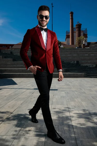 Ευτυχισμένος νεαρός κομψός άντρας που κάνει βόλτες και φοράει κόκκινο βελούδο σμόκιν — Φωτογραφία Αρχείου