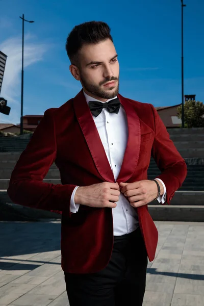 Concerned young elegant man arranging coat outside — Stock Photo, Image