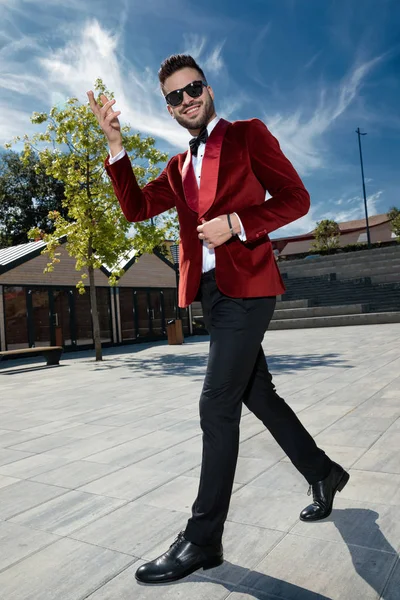 Enthousiaste jonge elegante man wandelen en zwaaien — Stockfoto