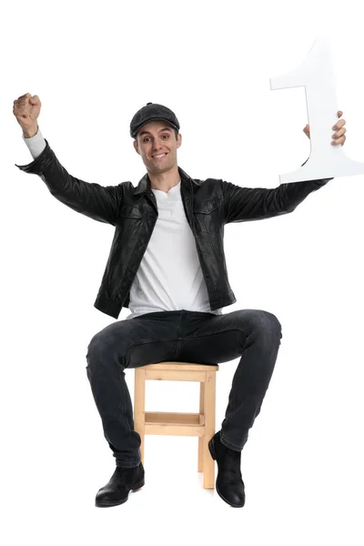 Oturmuş rahat adam ellerini yukarı tutarak ve bir numaralı muzaffer — Stok fotoğraf