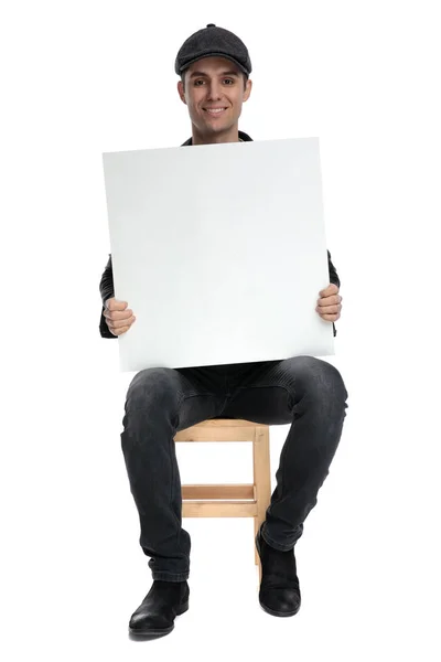 Сидящий случайный человек держит рекламный щит на руках счастливым — стоковое фото