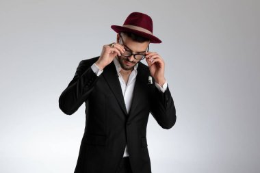 işadamı ayakta ve gözlüklerini çıkarıyor