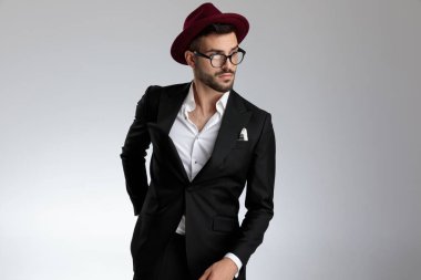 arkasında eliyle duran işadamı dalgın lara bakıyor