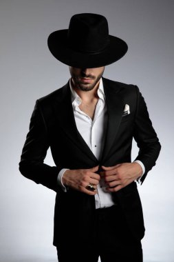 smokin ve siyah şapka giyen gizemli genç adam