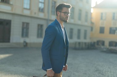 bir kentsel sahnede açık duran akıllı rahat adam yan görünümü