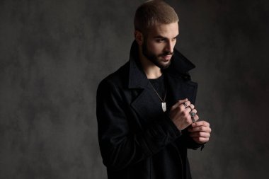 siyah longcoat giyen ve yan bakıyor emin genç model