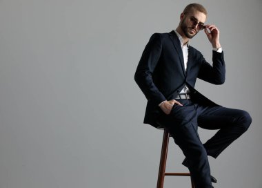 bir bacak la oturan işadamı güneş gözlüğü sabitleme istirahat