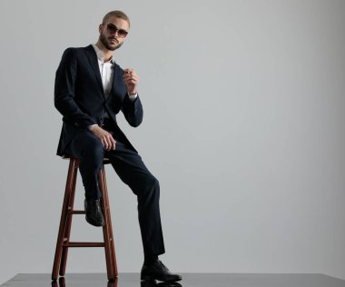 eli bacağına yaslanıp oturan işadamı ciddi