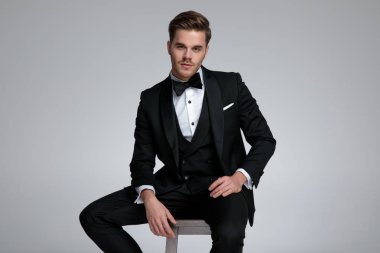 çekici modern damat siyah takım elbise ve papyon giyiyor