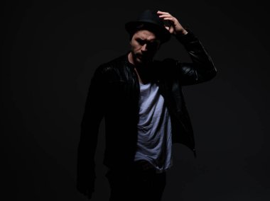 deri ceket ve şapka giyen model