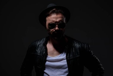 gri arka planda deri ceket giyen dramatik serin adam