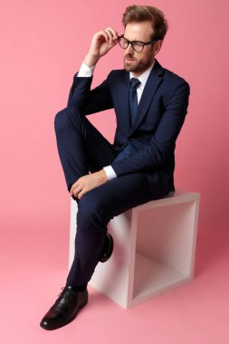 bir bacak sandalyesabitleme gözlük istirahat ile oturan işadamı