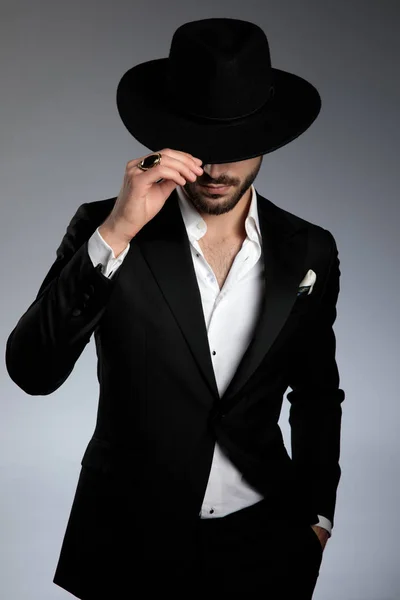 Misteriosa joven modelo tirando sombrero abajo y saludando — Foto de Stock