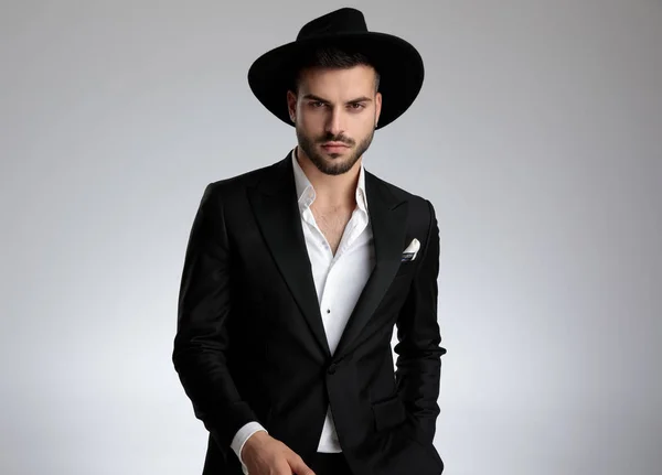Modelo de moda arrogante vestindo smoking e chapéu preto — Fotografia de Stock
