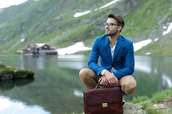 Умный случайный человек, любующийся природой и держащий чемодан — стоковое фото