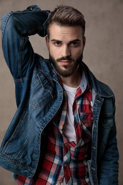 Casual jeune homme portant une veste en denim bleu sur fond gris — Photo