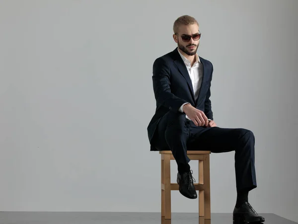 ペンシを見て椅子に座って足を置いているビジネスマン — ストック写真